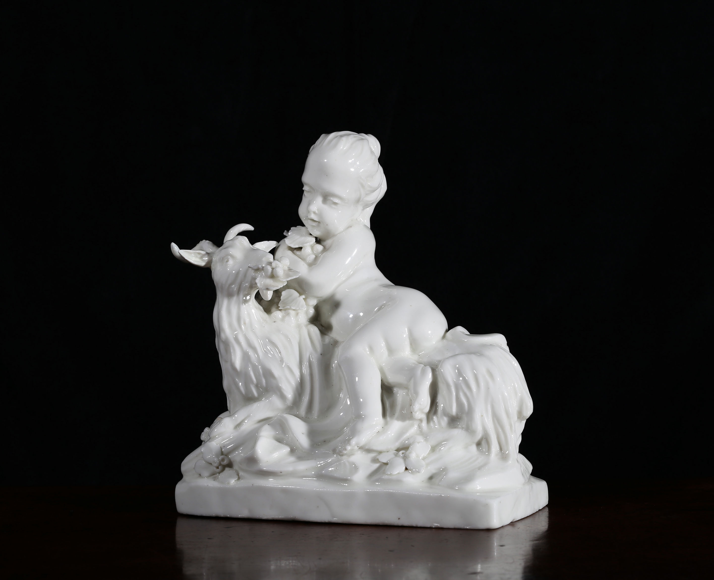A white French figure of a child with a recumbent goat, probably Saint-Cloud