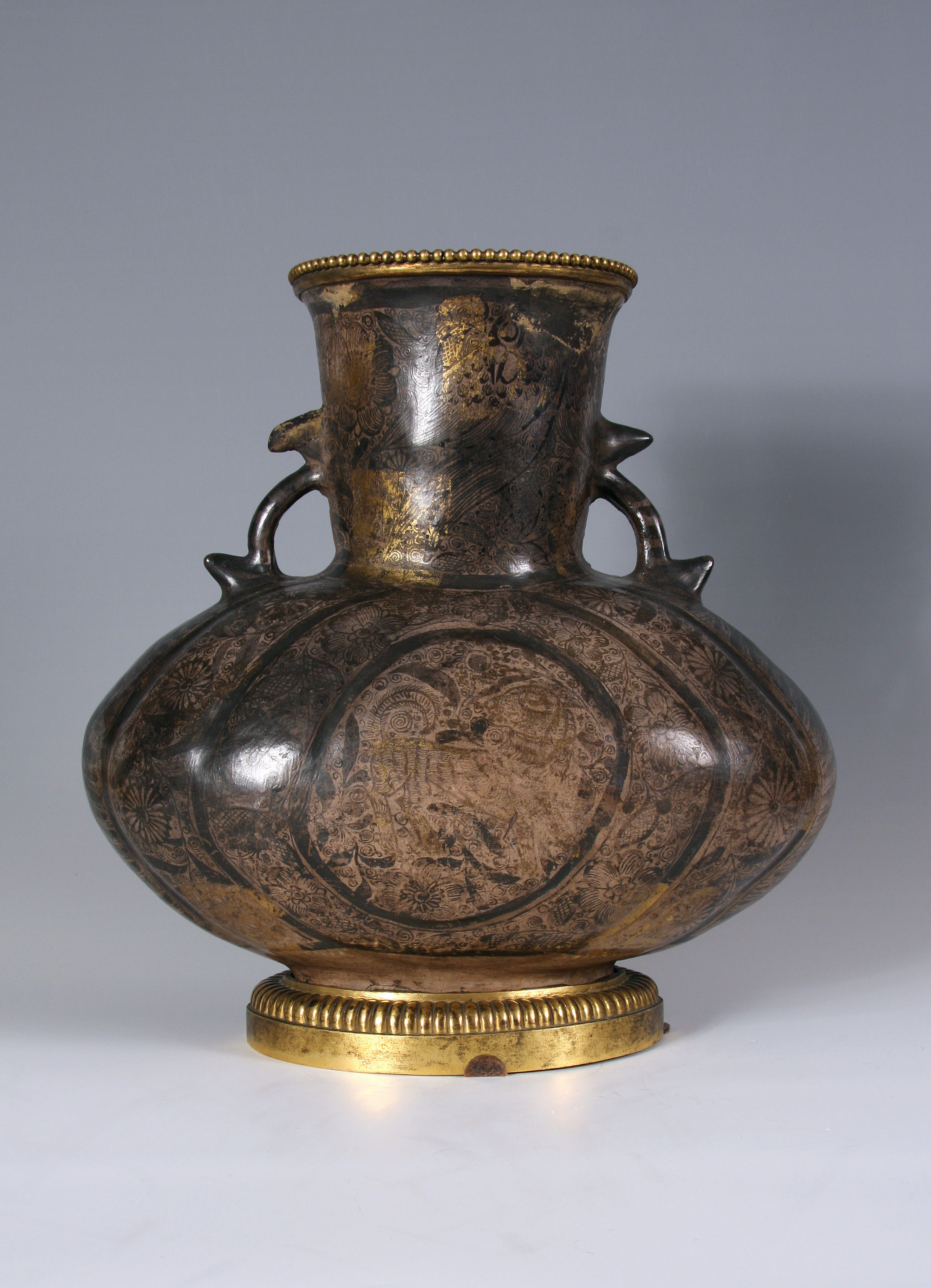 A Tonalá (Guadalajara) burnished earthenware two-handled vase, jarrón, densely painted in black with floral scrolls, birds and stylised lions with areas of applied gold leaf